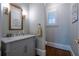 Stylish powder room with elegant fixtures, wood floor, and a decorative mirror at 225 Ansley Close, Roswell, GA 30075