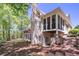 Exterior elevation of a large brick home with a screened porch and wooden deck at 225 Ansley Close, Roswell, GA 30075