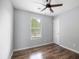Cozy bedroom with hardwood floors, a ceiling fan, and a bright window view at 3019 Havenwood Way, Stonecrest, GA 30038