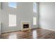 Spacious living room featuring a cozy fireplace, hardwood floors, and large windows at 3019 Havenwood Way, Stonecrest, GA 30038