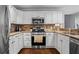 Modern kitchen featuring stainless steel appliances, granite counters, and white cabinetry at 3570 W Hampton Nw Dr, Marietta, GA 30064