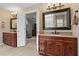 Dual vanity bathroom featuring wood cabinetry, stone countertop, and tile flooring, perfect for morning routines at 3570 W Hampton Nw Dr, Marietta, GA 30064