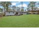 Large backyard with well-manicured lawn, patio, and the home's exterior in a serene setting at 3983 E Hilda Cir, Decatur, GA 30035