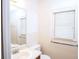Bright bathroom featuring a sink with a large mirror and a window with white blinds at 746 Oak Terrace Ter, Norcross, GA 30071