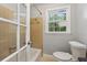 Cozy bathroom features a tub with a shower, a toilet, and a window that offers natural light at 756 Butler Ct, Lawrenceville, GA 30044