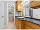 Well-lit bathroom showcasing wooden cabinets, dark countertops, and a view to the adjacent room at 756 Butler Ct, Lawrenceville, GA 30044