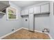Bright laundry room with ample storage, a window, and tile floors, offering convenience and functionality at 756 Butler Ct, Lawrenceville, GA 30044
