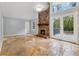 Cozy living room featuring a brick fireplace, large windows, and stone tile flooring at 756 Butler Ct, Lawrenceville, GA 30044