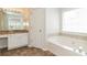 Bathroom featuring a tub, tile floor, vanity with granite counter and a window providing natural light at 2168 Sugar Maple Nw Cv, Acworth, GA 30101