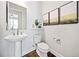Elegant half-bath with pedestal sink, decorative mirror, and stylish wall art at 234 Fieldbrook Xing, Canton, GA 30115