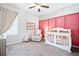 Charming Bedroom with pink accent wall, white crib, chair, and decor at 234 Fieldbrook Xing, Canton, GA 30115