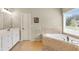 This bathroom features a soaking tub, tile surround, and large vanity at 2369 Apalachee Crucis Ln, Dacula, GA 30019