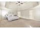 Bright bedroom with neutral walls, carpet flooring, and a tray ceiling with fan at 2369 Apalachee Crucis Ln, Dacula, GA 30019
