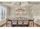 Elegant dining room with a coffered ceiling, wainscoting, and a stylish chandelier at 2369 Apalachee Crucis Ln, Dacula, GA 30019