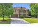 Charming brick two-story home with a well-manicured lawn, mature trees, and a two-car garage at 2369 Apalachee Crucis Ln, Dacula, GA 30019