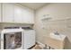 Convenient laundry room equipped with modern washer, dryer, and a utility sink at 2369 Apalachee Crucis Ln, Dacula, GA 30019