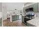 Open-concept kitchen with modern green cabinetry, granite countertops, and stainless steel appliances at 2500 Grand Manor Ct, Marietta, GA 30068