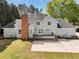 Back exterior featuring deck, patio, and spacious green yard with mature trees surrounding the property at 3175 Old Jonesboro Rd, Fairburn, GA 30213