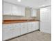Basement area includes white cabinets, a sink, and tile flooring offering functionality and storage space at 3175 Old Jonesboro Rd, Fairburn, GA 30213
