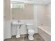 Basement bathroom featuring a pedestal sink, toilet, and a combined tub and shower with tiled walls at 3175 Old Jonesboro Rd, Fairburn, GA 30213