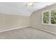 Bedroom with neutral walls, carpet, and a ceiling fan, and a large window with a view at 3175 Old Jonesboro Rd, Fairburn, GA 30213