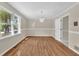 Open dining room with hardwood flooring, decorative chandelier, and large window with backyard view at 3175 Old Jonesboro Rd, Fairburn, GA 30213