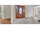 Home foyer with stone-look tile flooring, wooden front door, and white bi-fold doors to closet at 3175 Old Jonesboro Rd, Fairburn, GA 30213