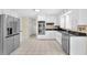 Modern kitchen boasts white cabinets, stainless steel appliances, tile floors, and ample counter space at 3175 Old Jonesboro Rd, Fairburn, GA 30213