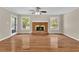 Bright living room featuring hardwood floors, brick fireplace, ceiling fan, and access to the backyard at 3175 Old Jonesboro Rd, Fairburn, GA 30213