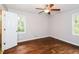 Bright bedroom with hardwood floors, two windows, and a white door at 3773 Sarahs Ln, Tucker, GA 30084