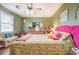 Bright bedroom featuring a colorful tufted headboard, chandelier, and natural light at 3557 Bill Gardner Pkwy, Locust Grove, GA 30248