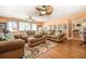 Comfortable living room with wood floors, ceiling fan, and view to other living spaces at 3557 Bill Gardner Pkwy, Locust Grove, GA 30248