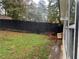 View of a fenced backyard featuring grass and a dog house near the house at 1506 Ravenel Rd, Conley, GA 30288