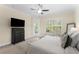 Cozy bedroom featuring a large TV, access to the balcony, and natural light, enhancing the relaxation at 4457 Equity Ct, Ellenwood, GA 30294