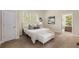 Serene bedroom featuring a comfortable bed, soft bench, natural light, and neutral color scheme for optimal relaxation at 4457 Equity Ct, Ellenwood, GA 30294