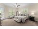 Bright bedroom featuring a ceiling fan, natural light, and neutral decor, creating a serene and inviting atmosphere at 4457 Equity Ct, Ellenwood, GA 30294