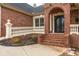 Close-up of the brick front porch featuring an arched entryway and decorative railings at 4457 Equity Ct, Ellenwood, GA 30294