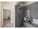 Accessible walk-in shower with gray tile, seating, and a handheld shower head at 4457 Equity Ct, Ellenwood, GA 30294