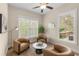 Bright sitting area featuring three chairs, a round coffee table, and abundant natural light at 4457 Equity Ct, Ellenwood, GA 30294