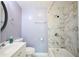 Bathroom with a shower and tub combo featuring marble tiling and chrome fixtures at 5251 Joan Of Arc Pl, Atlanta, GA 30349