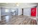 Open-concept living room with wood floors, view of the kitchen, and an inviting red front door at 5251 Joan Of Arc Pl, Atlanta, GA 30349