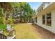 Spacious backyard featuring a manicured lawn, mature trees, seating, and a fire pit at 133 Newcastle Walk, Woodstock, GA 30188