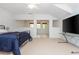 Spacious bedroom with a large TV, neutral carpet, and a cozy sitting area with lots of light at 133 Newcastle Walk, Woodstock, GA 30188