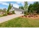 Home exterior showcasing a well-maintained lawn, a driveway, and mature landscaping at 133 Newcastle Walk, Woodstock, GA 30188