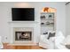 Close up of a cozy fireplace featuring a mantle, built-in shelving, and a wall-mounted television at 133 Newcastle Walk, Woodstock, GA 30188