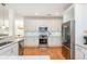 Bright kitchen with white cabinets, granite countertops, and modern stainless steel appliances at 133 Newcastle Walk, Woodstock, GA 30188