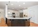 Well-lit kitchen with white cabinets, stainless appliances, granite counters and breakfast bar at 133 Newcastle Walk, Woodstock, GA 30188