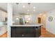 Open kitchen with black breakfast bar, white cabinets, and stainless steel appliances at 133 Newcastle Walk, Woodstock, GA 30188