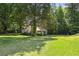 Well-maintained home surrounded by mature trees and a spacious green lawn at 3750 Mckown Rd, Douglasville, GA 30134