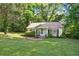 Inviting single-story home with a cozy front yard and a traditional design nestled in a verdant, tree-lined setting at 3750 Mckown Rd, Douglasville, GA 30134